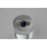 A sapphire and diamond three stone ring, central claw set sapphire flanked by old cut diamonds