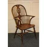 A Windsor armchair with pierced wheel back splat, on turned legs united by an 'H' stretcher