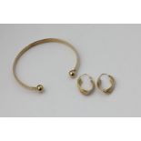 A 9ct yellow gold bangle, 18.9g, a pair of gold loop earrings, 2g