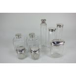 A collection of eight Victorian and later silver lidded cut glass dressing table jars and bottles