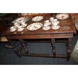 An oak plank top rectangular side table, on turned legs, with four turned supports over