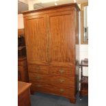 A George III style mahogany linen press with two panel doors enclosing four shelves, the base with