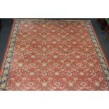 A William Morris style wool carpet, the floral pattern on orange ground, within multi line