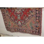 A Mahal style Persian wool rug, the central floral design in shades of blue on red ground, 200cm