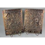 A pair of copper two-branch wall lights, each with embossed back panel decorated with a dragon and a