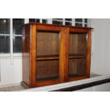 A Victorian fruitwood glazed collector's cabinet, the two doors enclosing two shelves on bun feet