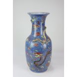A Chinese porcelain baluster vase decorated with black and red dragons amongst floral sprays, on