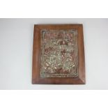 A copper wall plaque depicting figures gathered in an interior, mounted on wooden panel, 30cm by