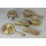 A George V silver gilt dressing table set of two hand brushes, two rectangular brushes, hand
