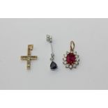 A ruby and diamond oval pendant, a sapphire and diamond pendant, and a diamond cross pendant