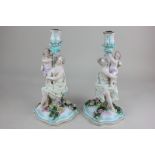 A pair of Sitzendorf porcelain candlesticks, each with a woman and child, on floral encrusted