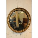 A large circular convex gilt ball shot wall mirror, 75cm diameter