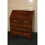 An Edwardian mahogany inlaid bureau, the fall with oval flame veneered panel enclosing fitted