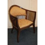 An Edwardian inlaid mahogany tub chair with gold floral upholstered back and seat, and slatted