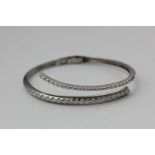 A 14ct white gold and diamond sprung bangle (a/f)