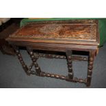 A Victorian carved oak side table, the top with central medallion and scroll surround, on bobbin