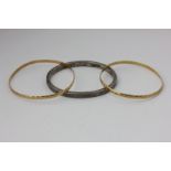 A pair of gold bangles, 12g, a silver bangle