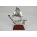 A Continental white metal model of a Chinese sailing ship on stand, 19cm high