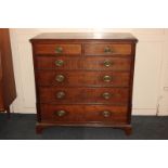 A George III oak chest of two short over four long drawers, with brass drop handles and oval