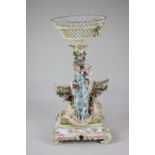 A Continental porcelain table centrepiece with figural and floral column supporting a lattice