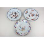 A Chinese porcelain famille rose plate decorated with flowers and a bowl of fruit, 23cm diameter,