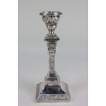 A German 830 silver column candlestick with floral swag and roundel embossed design, 18cm high