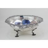 An Edward VII silver circular bowl faceted form with pierced and cast border of shields and scrolls,