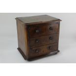 A small Victorian walnut table top chest of three drawers, with turned knob handles, on flattened