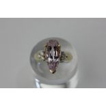 A kunzite and zircon ring, the pear cut stone three-claw set with a trefoil of zircons to each