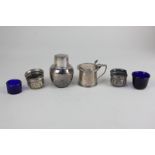 A George V silver mustard pot, cylindrical with lid and shell thumb plate and blue glass liner,