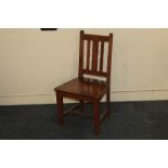 A child's wooden chair, with slatted back and solid seat