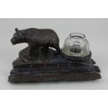A Black Forest carved wood desk stand with a bear beside a glass inkwell (missing cover), and a