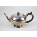 A George V silver teapot, circular shape with engraved border and wooden scroll handle, maker