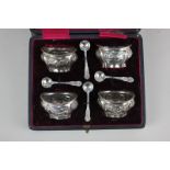 A cased Edward VII silver set of four salts, oval form with embossed floral decoration, maker