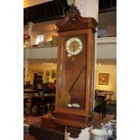 A walnut wall clock, the glazed case with carved design, initialled JJ, missing pendulum (a/f),