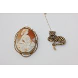 A 9ct gold, sapphire and ruby leopard brooch, and a 9ct gold shell cameo brooch