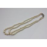 A two row pearl necklace, the graduated beads on a nine stone diamond clasp