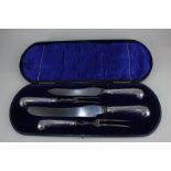 A George V silver handled carving set of two forks (one a/f), and two knives, in fitted case,