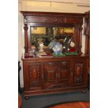 A Victorian style sideboard with raised mirror back and column supports, the base with an