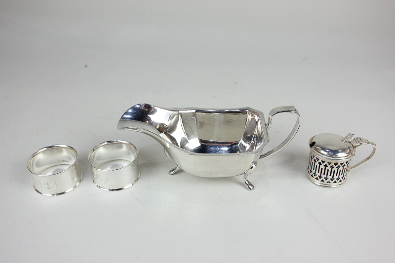 An Elizabeth II silver sauce boat, maker Emile Viner, Sheffield 1964, a pair of silver napkin rings,