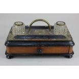 A metal bound and ebonised wood desk stand with carry handle above a single drawer, on bun feet,