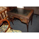 An Edwardian kneehole desk with rectangular black leather with side drop flaps above frieze drawer