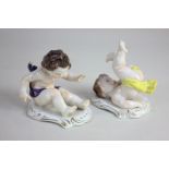 A pair of Continental porcelain figures of cherubs in playful poses, marks to base, 10cm, (a/f)
