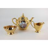 A Bavarian porcelain teapot decorated with two panels depicting classical figures, on gold