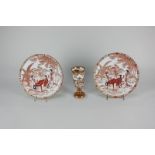 A pair of small Japanese Kutani side plates decorated with figures at a table in a garden setting,