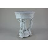 A Bavarian blanc de chine centrepiece, the central bowl on pedestal with three-cherub support,