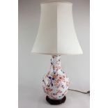 A porcelain baluster table lamp with floral decoration in the Imari palette, on wooden stand, 39cm