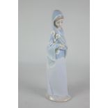 A Lladro porcelain figure of a lady carrying three lilies, 23cm, (a/f)