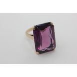 An amethyst dress ring, the large rectangular stone claw set in unmarked yellow gold