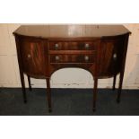 A Sheraton style mahogany bow-front sideboard with two central drawers and side cupboards with brass